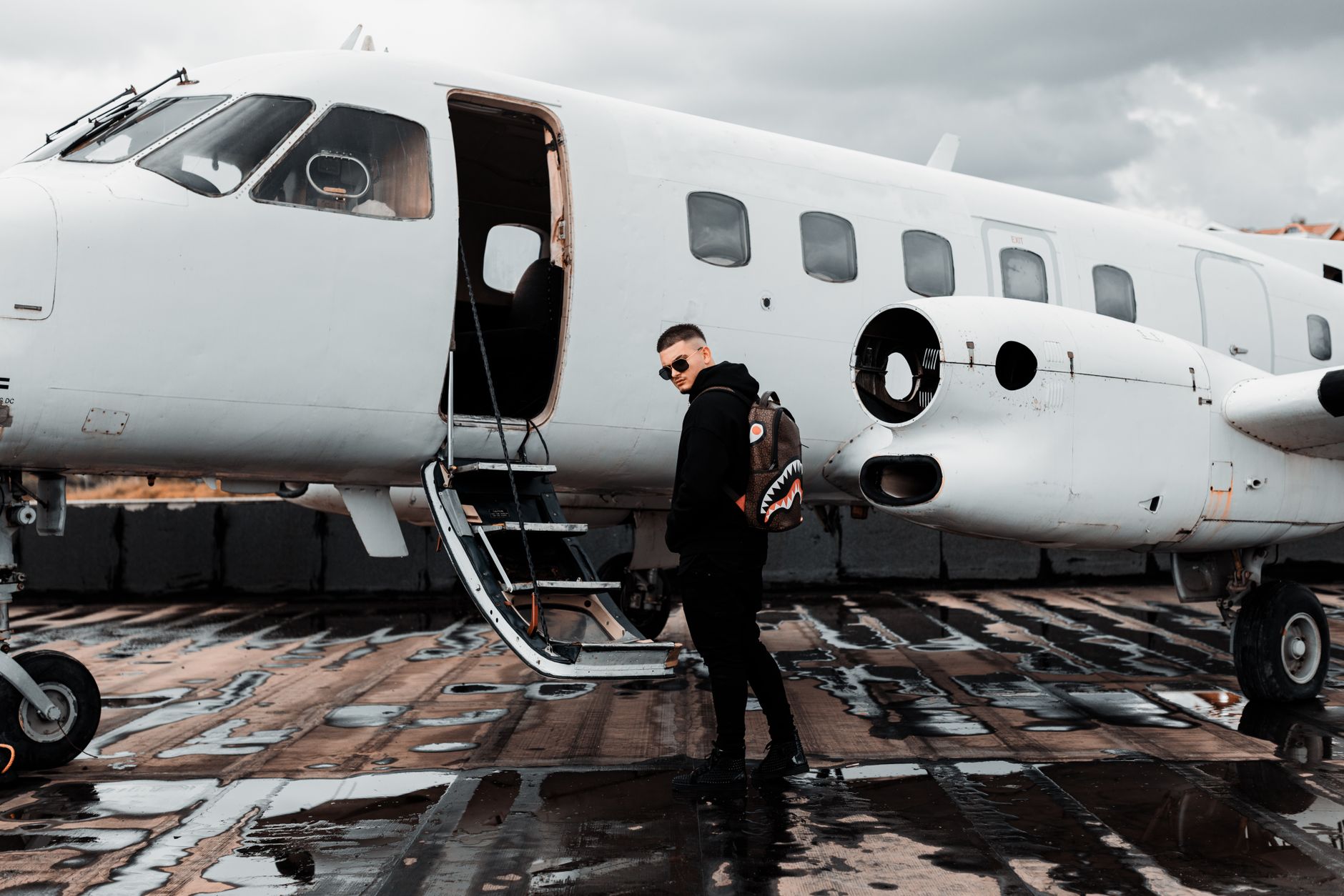 man with backpack standing by airplane