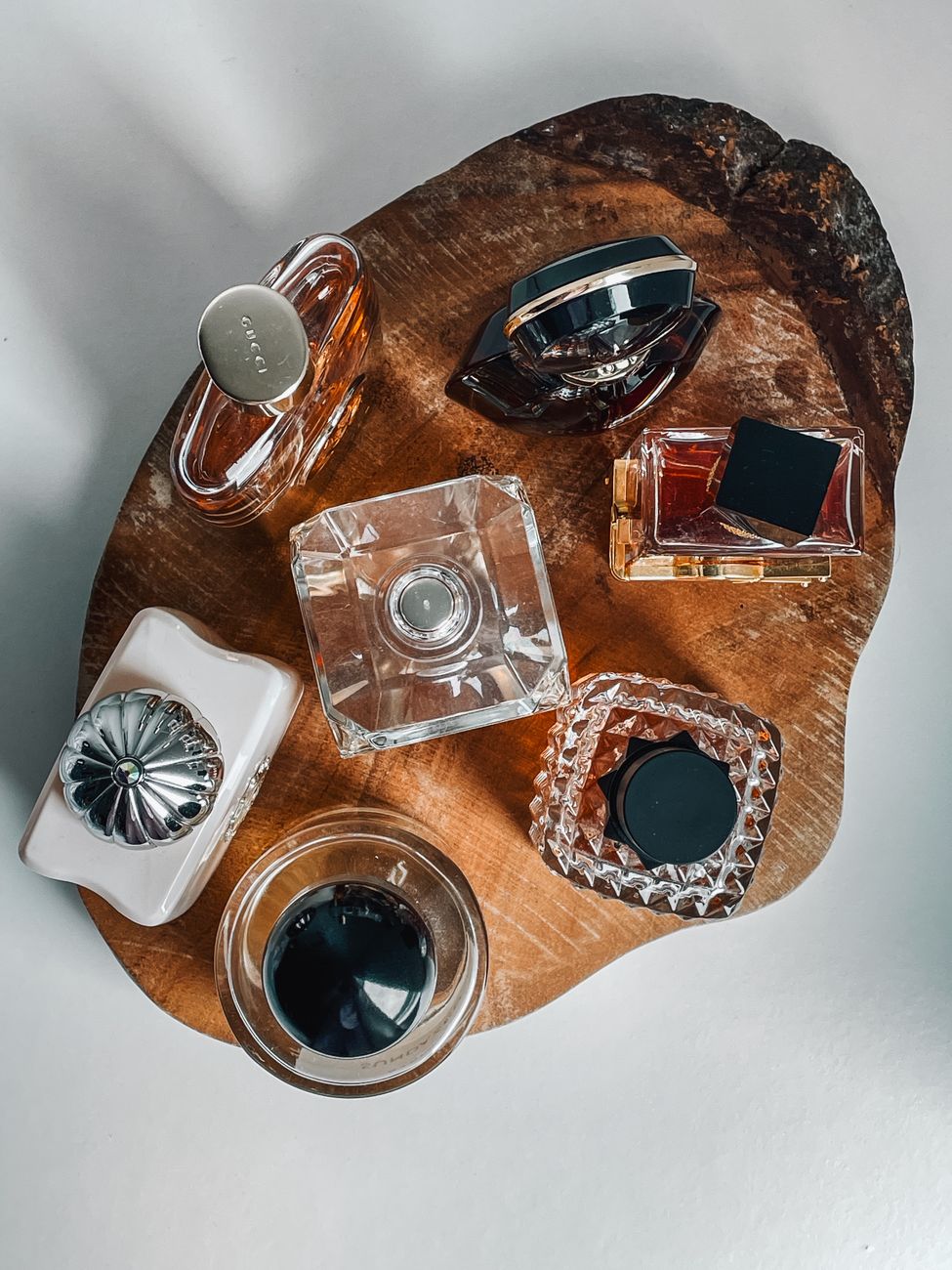 elegant perfume bottles on rustic wood tray