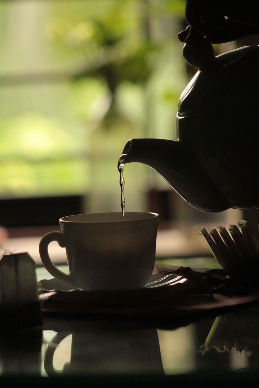 warm tea pouring into cup in cozy interior setting