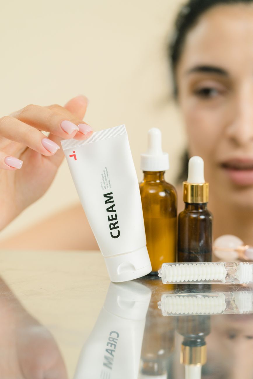 woman touching cream in plastic tube